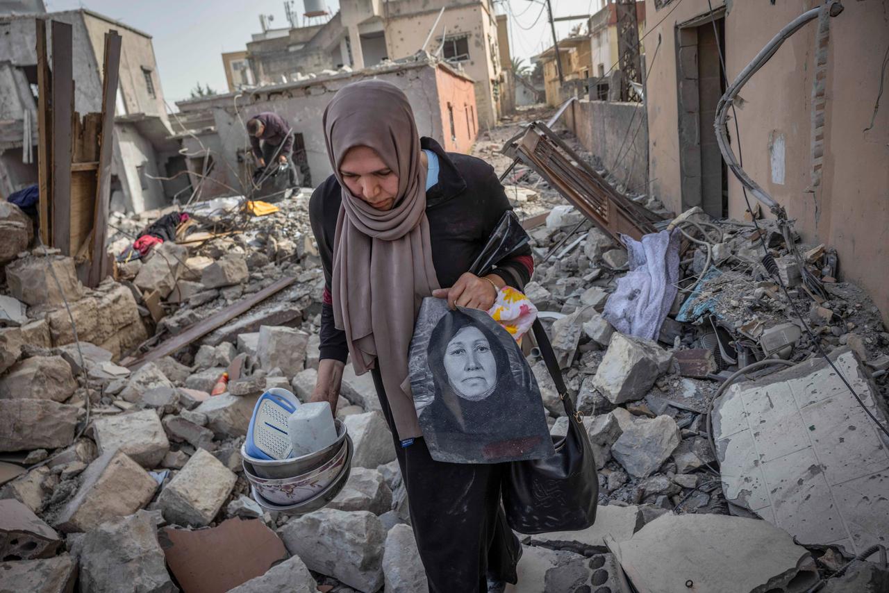 Samira Nazal récupère ses affaires, dont un portrait de sa mère, après une visite d'inspection dans son village de Srifa, où sa maison a été détruite, le 17 avril 2026