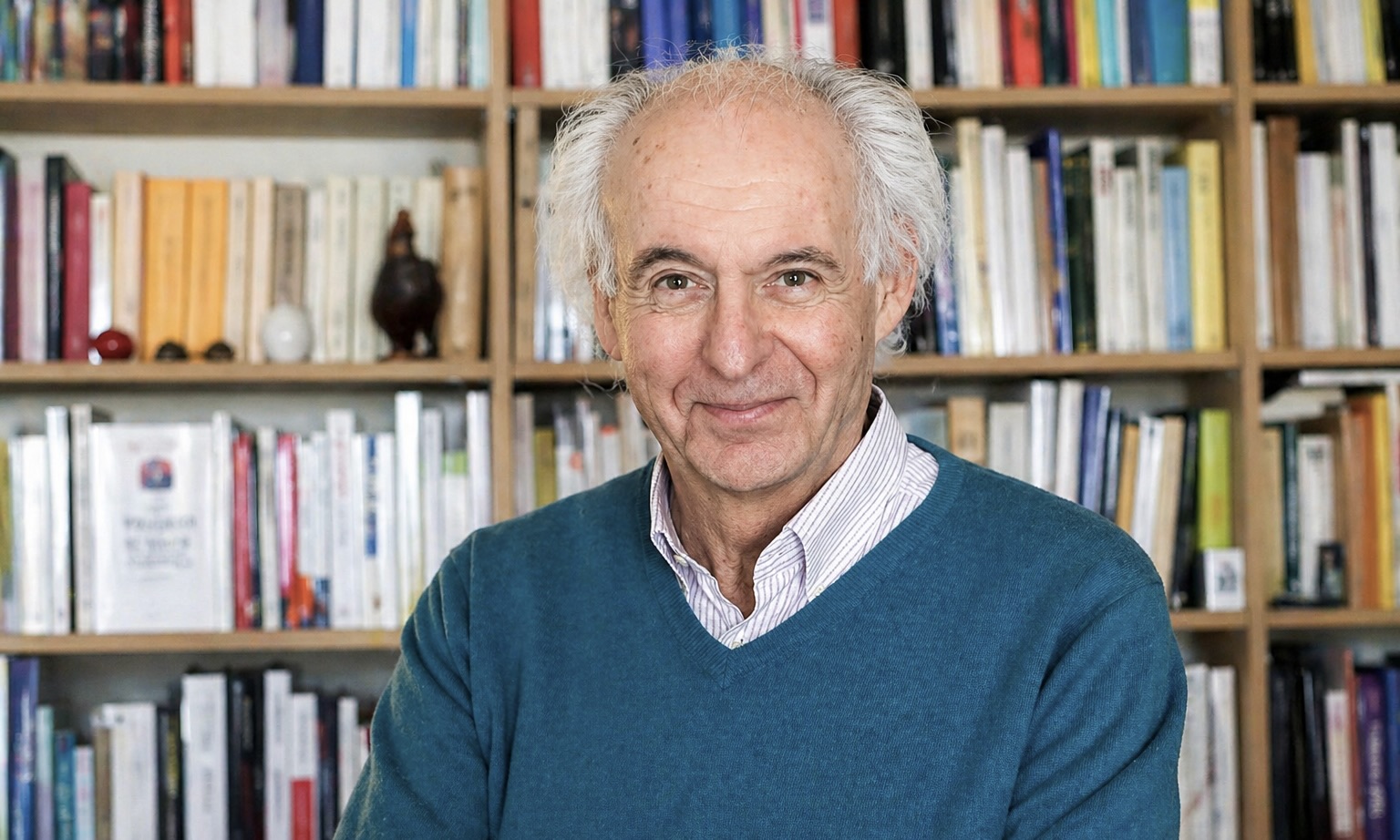 Le philosophe Roger-Pol Droit pose dans sa bibliothèque.