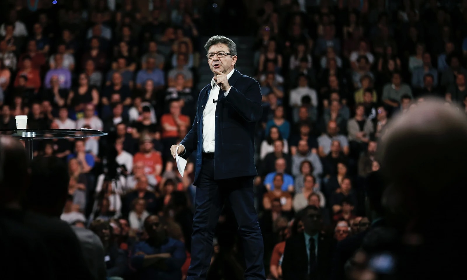 Jean-Luc Mélenchon délivre un discours au Havre. Il est debout sur une scène au milieu de ses militants.