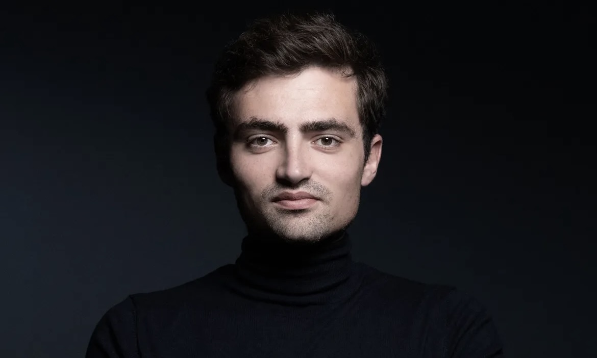 Portrait du philosophe et écrivain Nathan Devers, devant un fond noir.