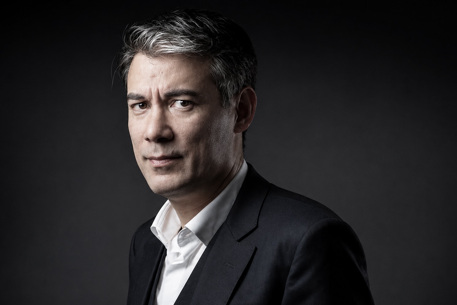 Portrait de Olivier Faure devant un fond gris.