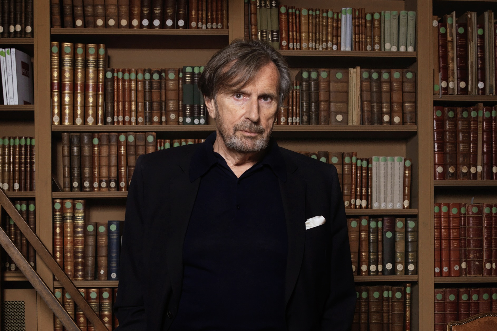 L’écrivain et académicien français Daniel Rondeau pose devant une bibliothèque de livres anciens.