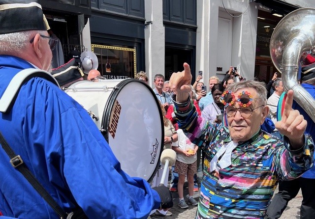 Fernando Arrabal dans la rue lors d'une fête il danse au milieu d'une fanfare.