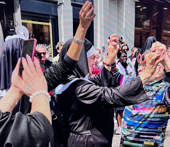 Fernando Arrabal dans la rue lors d'une fête il danse au milieu d'une fanfare.