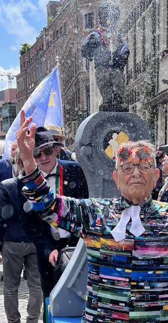 Fernando Arrabal dans la rue lors d'une fête il danse au milieu d'une fanfare.