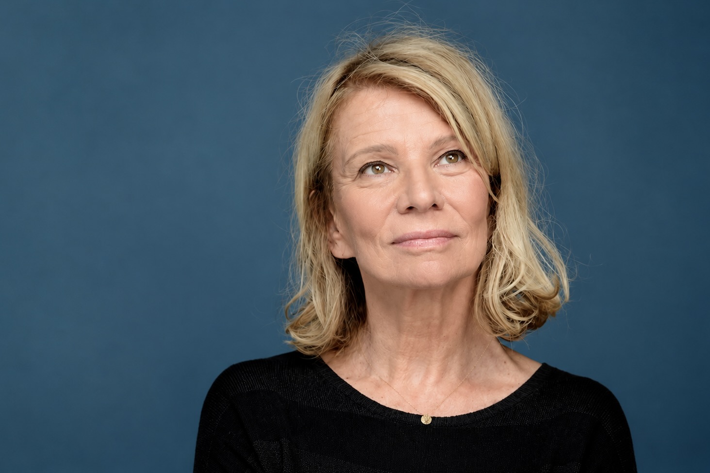 L’actrice française Nicole Garcia pose devant un fond bleu unis.