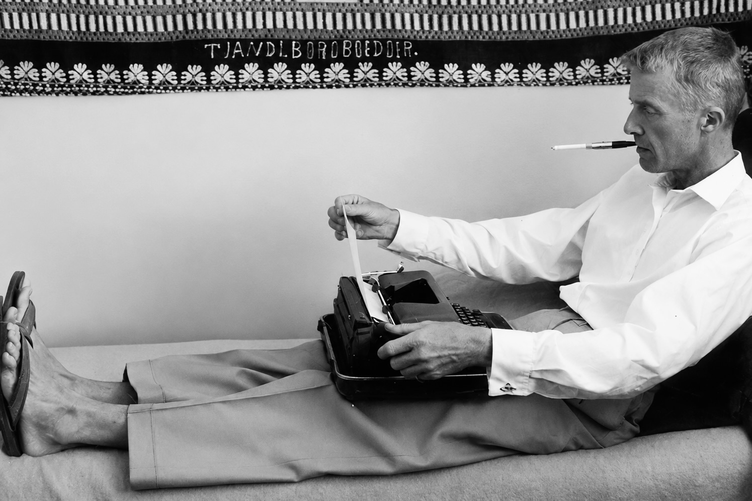 Paul Bowles à Tanger, il est allongé avec une machine à écrire sur les genoux.
