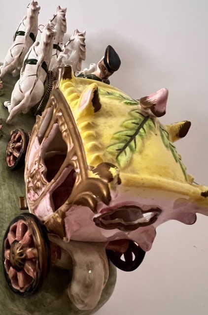 Carrosse miniature décoratif en céramique, tiré par quatre chevaux blancs, aux motifs floraux colorés.