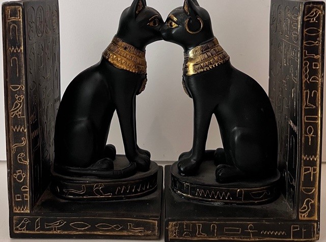 Paire de serre-livres représentant deux chats noirs de style égyptien ornés de colliers dorés, se faisant face.