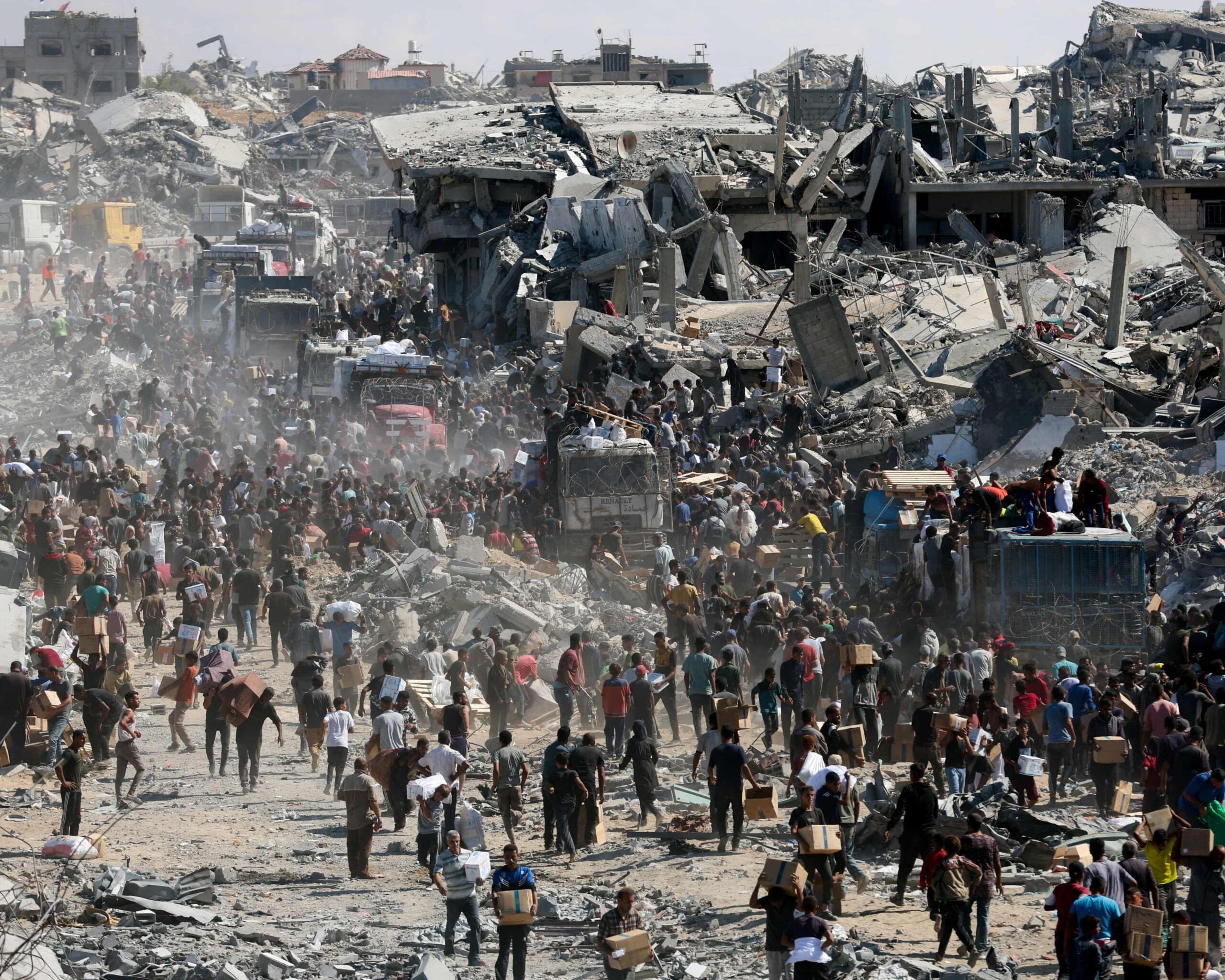 Des Palestiniens récupèrent de l'aide depuis des camions entrés à Gaza en octobre dernier.