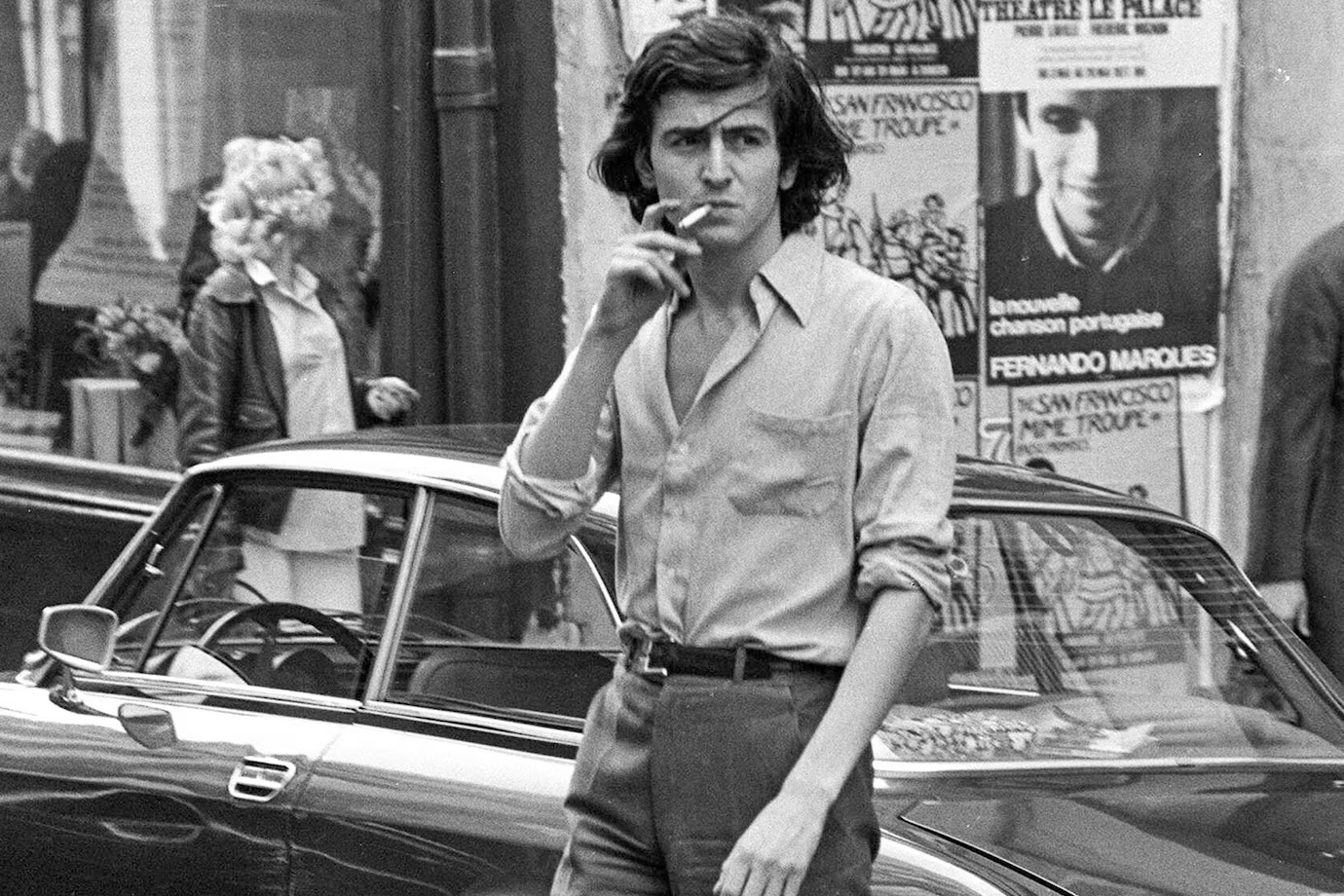 Bernard-Henri Lévy en 1977, il marche dans la rue en fumant une cigarette. Photo en noir et blanc.