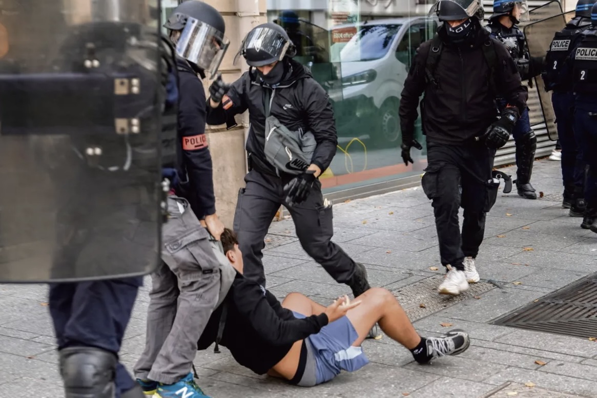 Des policiers traînent au sol un lycéen